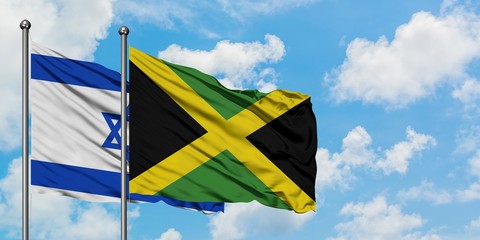 Israel and Jamaica flag waving in the wind against white cloudy blue sky together. Diplomacy concept, international relations.