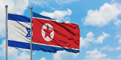 Israel and North Korea flag waving in the wind against white cloudy blue sky together. Diplomacy concept, international relations.