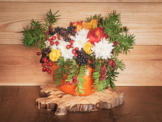 Autumn bouquet in a vase made out of pumpkin for Thanksgiving Day.