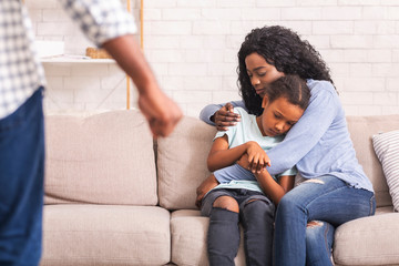 Afro mother and daughter suffering from domestic violence of father