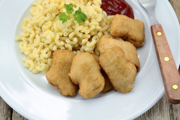 plate of chicken nuggets and coquillettes pasta