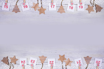 15-24 part of Advent calendar: sheets with numbers and wooden Christmas toys on wooden background...