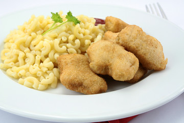 plate of chicken nuggets and coquillettes pasta