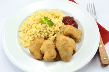 plate of chicken nuggets and coquillettes pasta