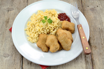 plate of chicken nuggets and coquillettes pasta