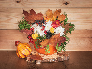 Autumn bouquet in a vase made out of pumpkin for Thanksgiving Day.