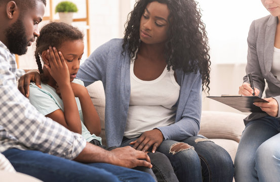 Little black girl and her parents at psychologist consultation