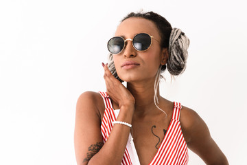 Serious young amazing african woman with dreads posing isolated over white wall background.