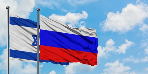 Israel and Russia flag waving in the wind against white cloudy blue sky together. Diplomacy concept, international relations.