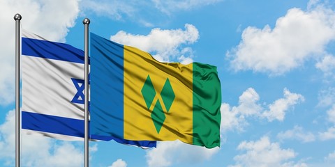 Israel and Saint Vincent And The Grenadines flag waving in the wind against white cloudy blue sky together. Diplomacy concept, international relations.