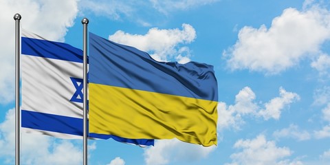 Israel and Ukraine flag waving in the wind against white cloudy blue sky together. Diplomacy concept, international relations.