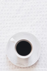 Morning coffee. A cup of coffee. Hot black coffee on the pure white knitted tablecloth