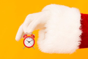 Santa holding retro red alarm clock on orange