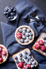 Tasty dessert with fresh blueberries and raspberries on a black background.