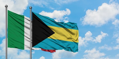 Italy and Bahamas flag waving in the wind against white cloudy blue sky together. Diplomacy concept, international relations.
