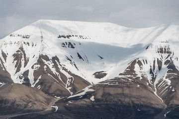 Snow covered mountains in cloudy weather in Svalbard
