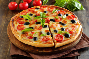 Sliced pizza with tomato and olives