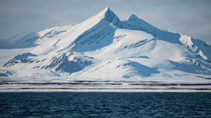 Snowy mountain peaks and slopes by an arctic fjord in Svalbard © Jani Katajisto