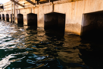 Gaps under a jetty in a sea port.