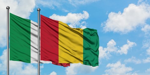 Italy and Guinea flag waving in the wind against white cloudy blue sky together. Diplomacy concept, international relations.
