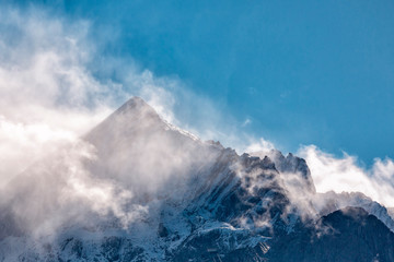 Snow-capped mountain peak in the Alps against a blue sky