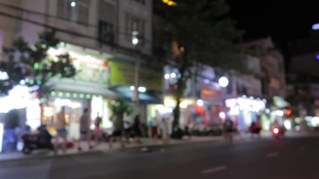 Vietnam's evening streets with lighting from shops, signboards, passing mopeds, motorbikes, cars and carts
