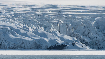 Glacier with crevasses and cracks in the ice in arctic Svalbard