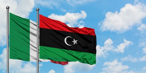 Italy and Libya flag waving in the wind against white cloudy blue sky together. Diplomacy concept,...