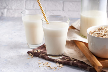 Healthy alternative milk. Homemade oat milk in glass and bottle on light table Lactose free Copy space
