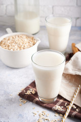 Healthy alternative milk. Homemade oat milk in glass and bottle on light table Lactose free