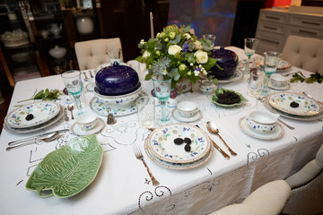Beautifully decorated table set with flowers, candles, plates and serviettes for wedding or another event in the restaurant.