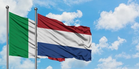 Italy and Netherlands flag waving in the wind against white cloudy blue sky together. Diplomacy concept, international relations.