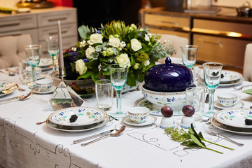 Beautifully decorated table set with flowers, candles, plates and serviettes for wedding or another event in the restaurant.