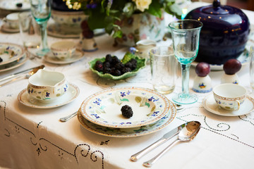 Beautifully decorated table set with flowers, candles, plates and serviettes for wedding or another event in the restaurant.