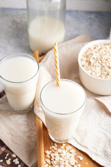 Healthy alternative milk. Homemade oat milk in glass and bottle on light table Lactose free