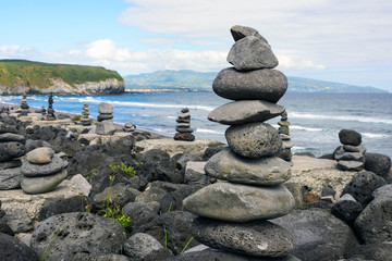 Stack of zen stones on beach.Cairns on the beautiful sea beach of Praia do Areal de Santa Barbara, island of San Miguel, Azores, Portugal.