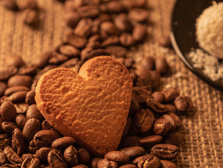 heart cookies on coffee beans on the background of burlap and other sweets