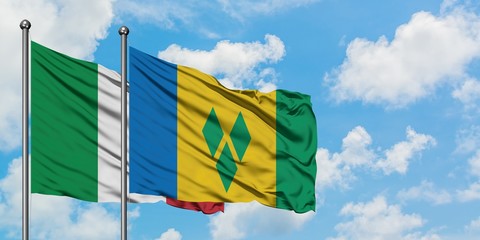 Italy and Saint Vincent And The Grenadines flag waving in the wind against white cloudy blue sky...
