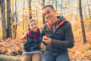 A portrait of a father with child in the autumn park