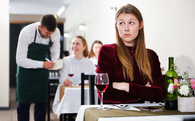 Fototapeta na wymiar Young female is having dinner alone in the restaurante