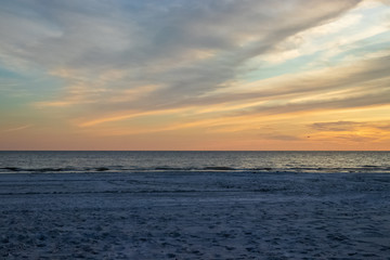 Sunset sky over Gulf of Mexico with bird silhouettes and ocean waves