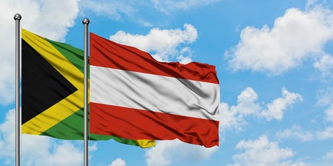 Jamaica and Austria flag waving in the wind against white cloudy blue sky together. Diplomacy concept, international relations.
