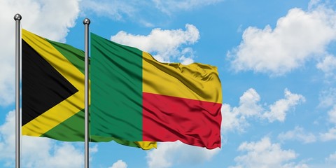 Jamaica and Benin flag waving in the wind against white cloudy blue sky together. Diplomacy concept, international relations.