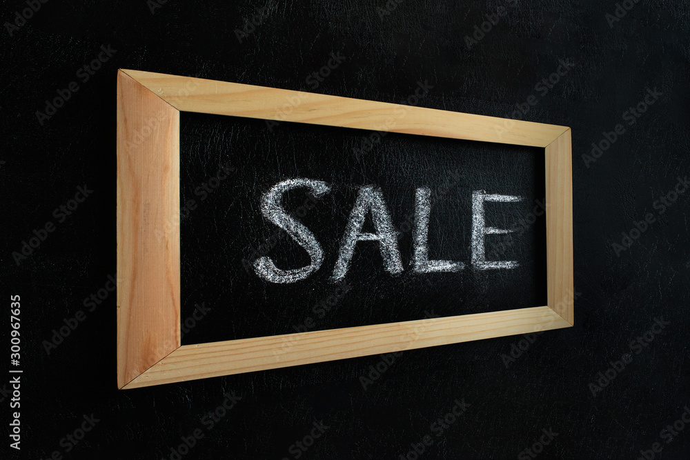 Wall mural sale written on blackboard. sale handwritten with white chalk on a blackboard in wooden frame.