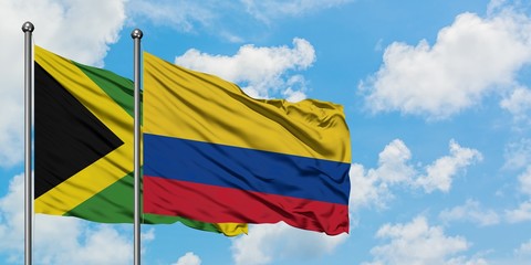 Jamaica and Colombia flag waving in the wind against white cloudy blue sky together. Diplomacy concept, international relations.