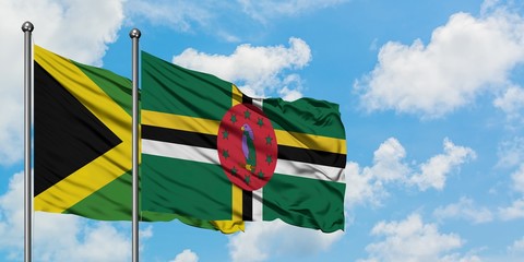 Jamaica and Dominica flag waving in the wind against white cloudy blue sky together. Diplomacy concept, international relations.