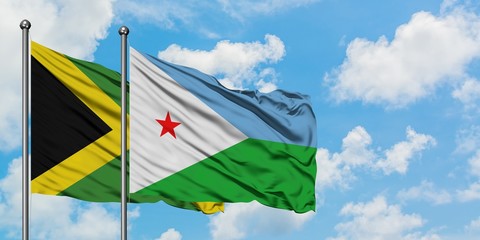 Jamaica and Djibouti flag waving in the wind against white cloudy blue sky together. Diplomacy concept, international relations.