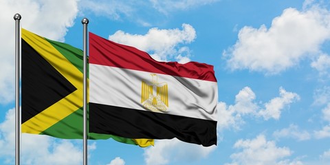 Jamaica and Egypt flag waving in the wind against white cloudy blue sky together. Diplomacy concept, international relations.