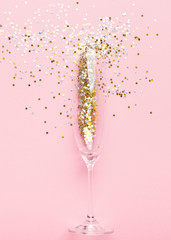 Champagne glass with gold tinsel on pink