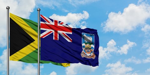 Jamaica and Falkland Islands flag waving in the wind against white cloudy blue sky together....
